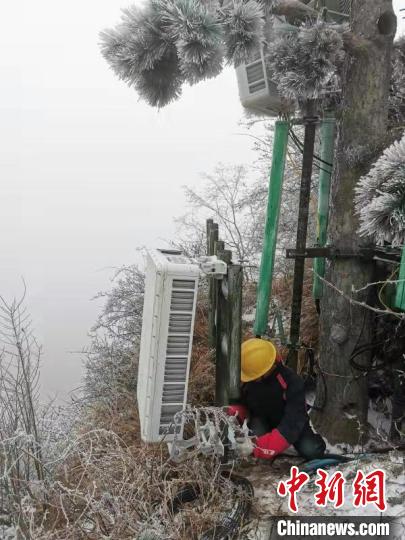 技术人员将数套每台约100斤的AAU设备(5G天线)人工搬运至金顶 王政 摄